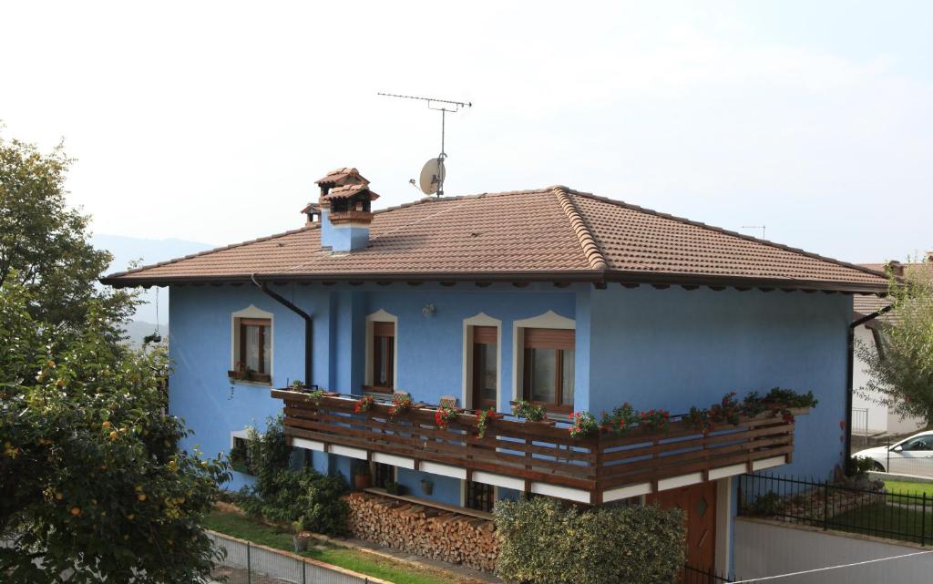 una casa azul con un pájaro en el techo en B&B All'Antica Fonte, en Forgaria nel Friuli