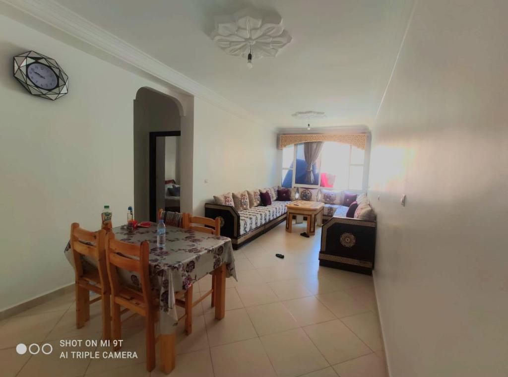 sala de estar con mesa y sofá en Oued laou ch², en Oued Laou