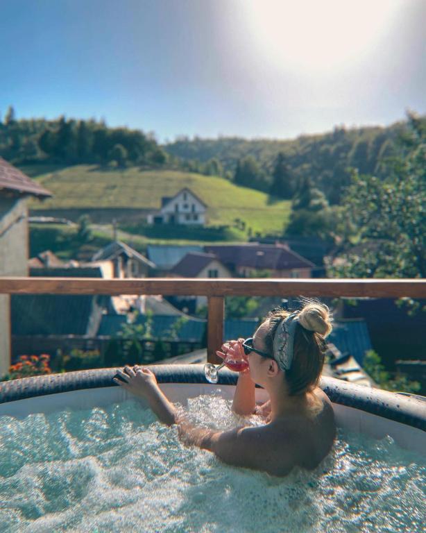 a woman in a jacuzzi in a swimming pool at Casa Fratila in Holbav