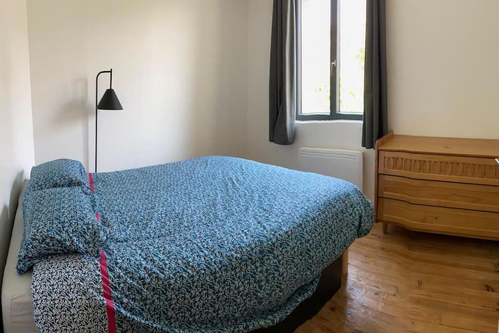 um quarto com uma cama, uma cómoda e uma janela em Maison Marceau Gruissan em Gruissan