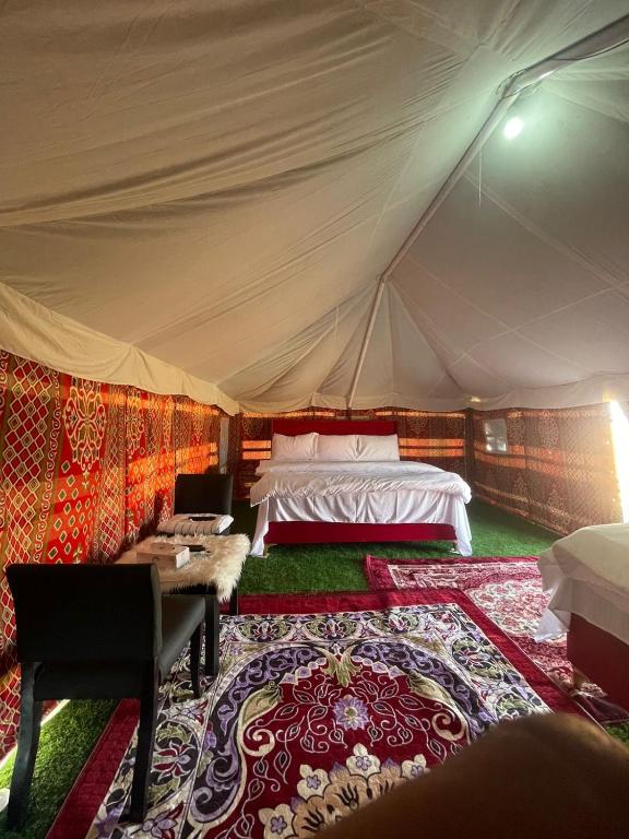 a bedroom in a tent with a bed and a rug at Moon Light Camp in Bidiyah