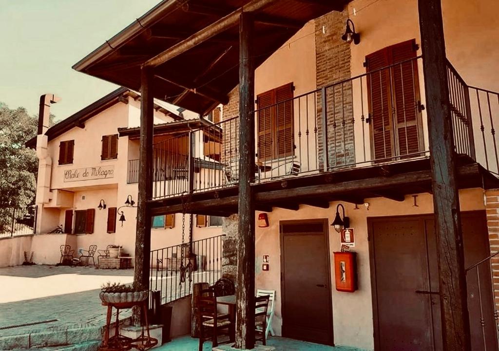 a building with a balcony and a table and chairs at Il vecchio granaio in Ruino