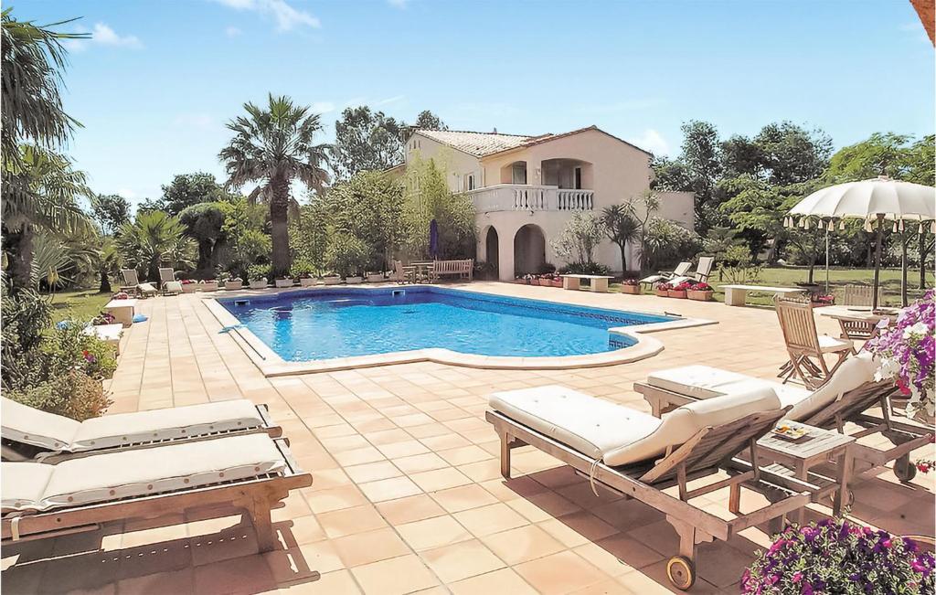 - une piscine avec des chaises et une maison dans l'établissement Amazing Apartment In Argels Sur Mer With Outdoor Swimming Pool, à Plage dʼArgelès