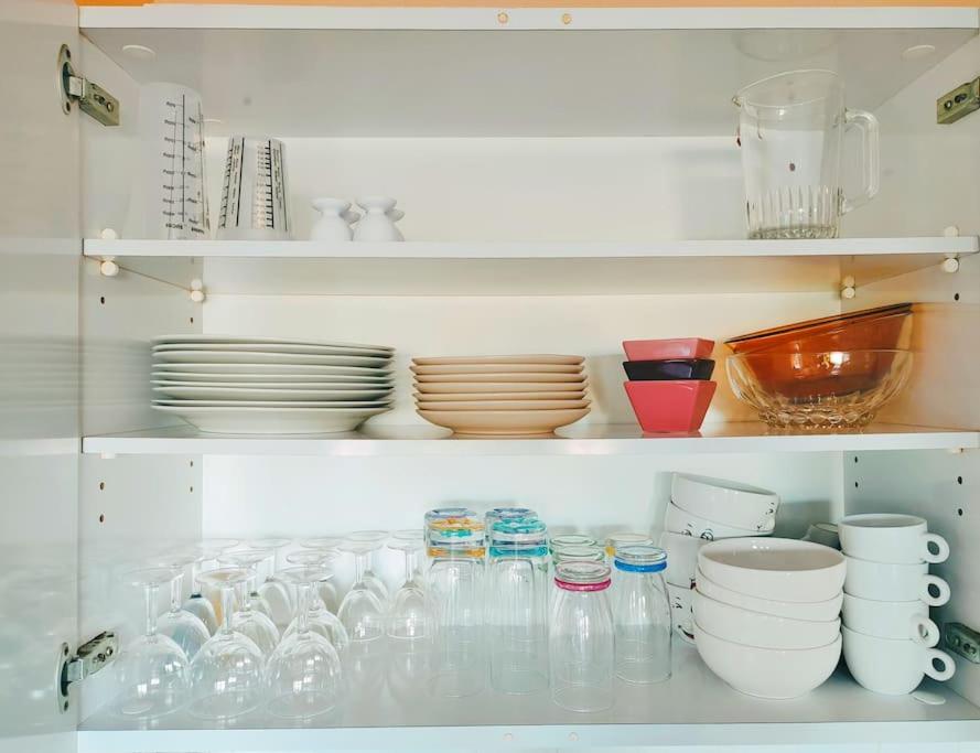 a cabinet filled with dishes and bowls and plates at Un cocon face à la mer in Plérin