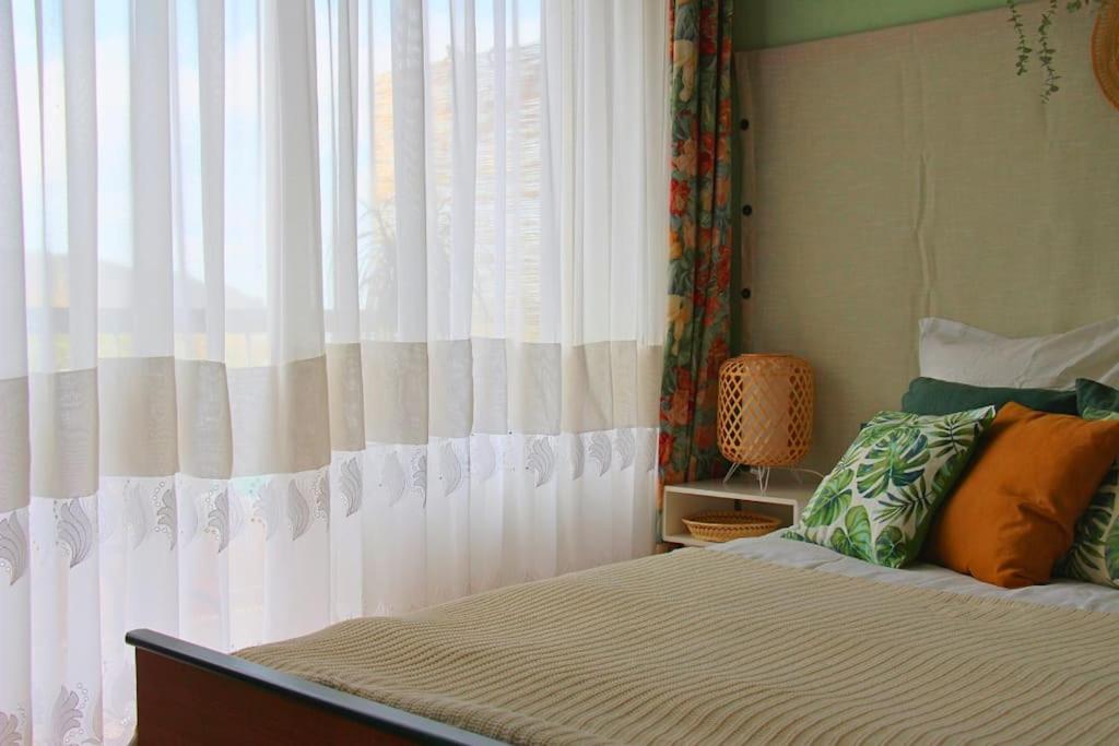 a bedroom with a bed with a white curtain at Un cocon face à la mer in Plérin