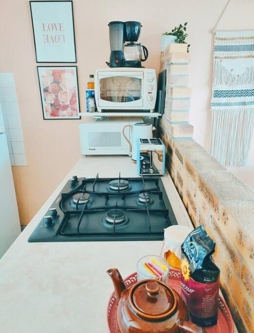 a stove top in a kitchen with a microwave at Un cocon face à la mer in Plérin