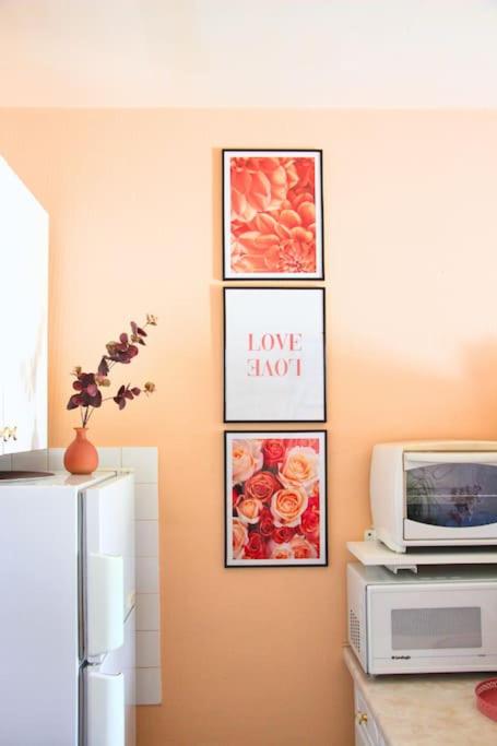 a kitchen with pictures on the wall and a refrigerator at Un cocon face à la mer in Plérin