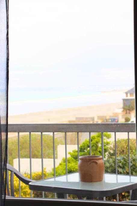 a table with a pot sitting on top of a balcony at Un cocon face à la mer in Plérin