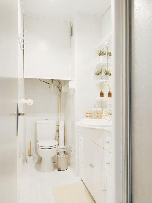 a white bathroom with a toilet and a sink at Un cocon face à la mer in Plérin
