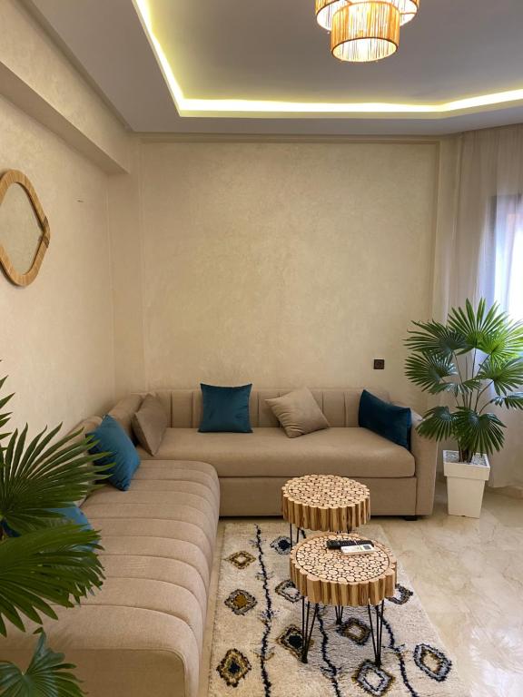 uma sala de estar com um sofá e duas mesas em Luxury & cosy apartment em Marrakech