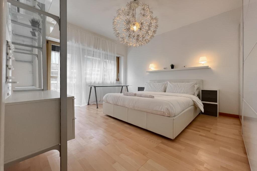 ローマにあるLa Casa di Romaの白いベッドルーム(ベッド1台、シャンデリア付)
