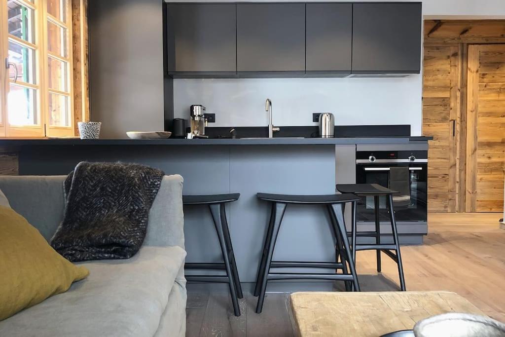 een keuken met een bank en een aanrecht met krukken bij Bianca appartement proche centre in Megève