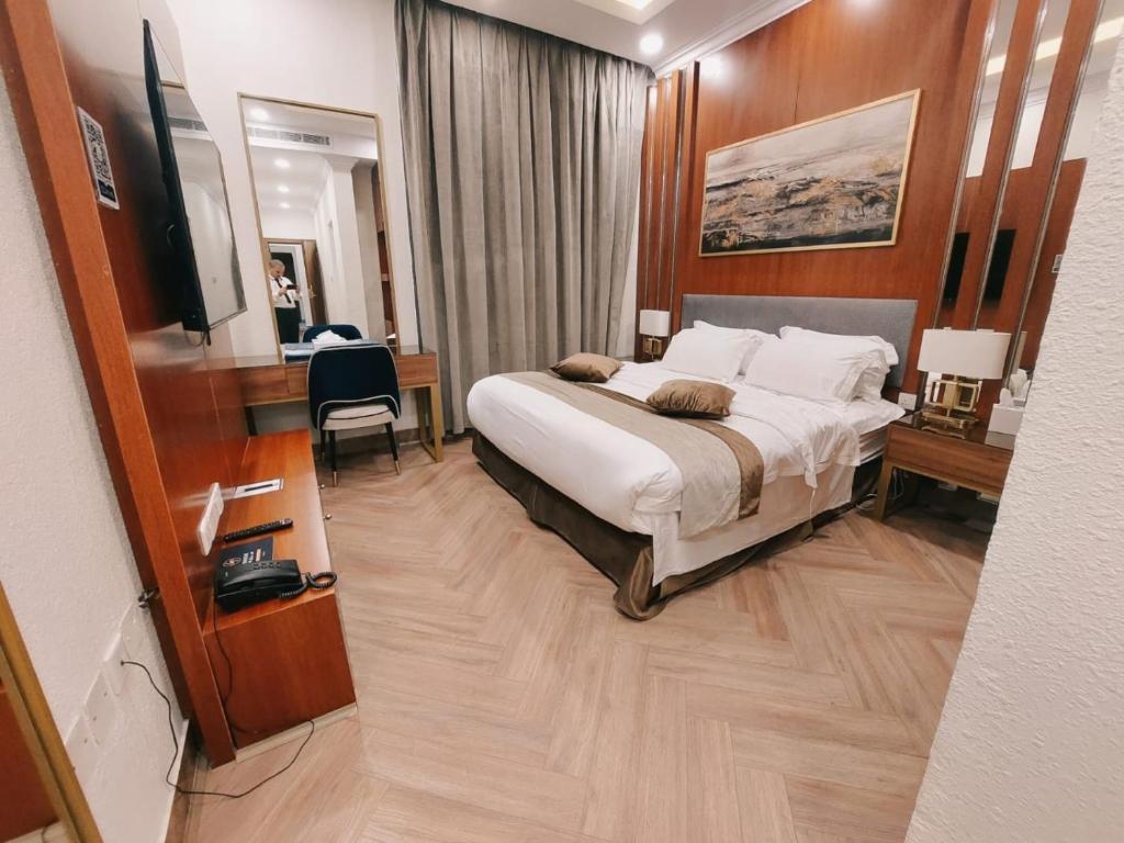 a hotel room with a large bed and a desk at Smayah Hotel in Riyadh