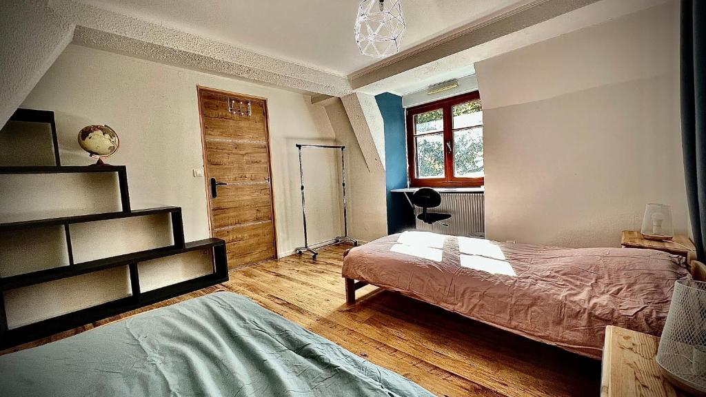una camera con letto e pavimento in legno di La jolie maison bleue avec terrasse a Kaysersberg