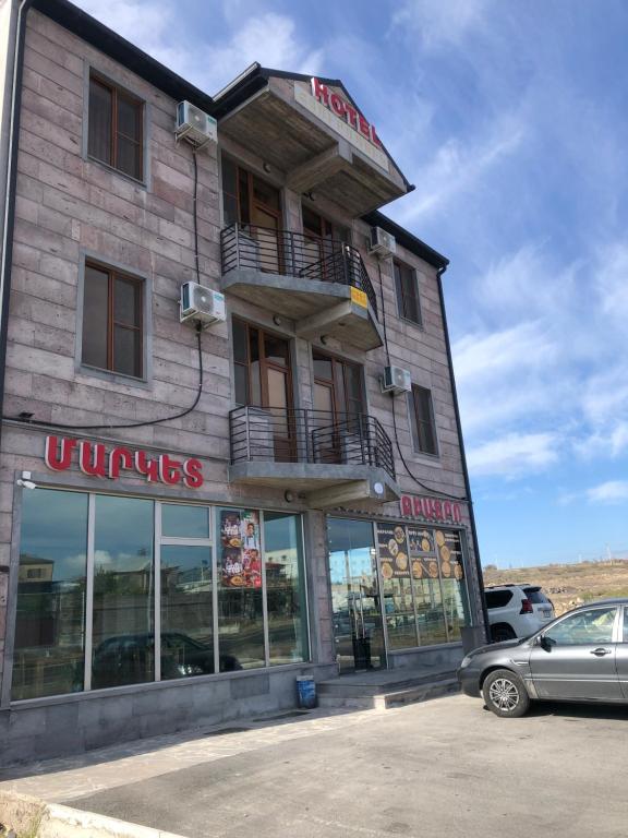 ein Gebäude mit einem davor geparkt in der Unterkunft Nigatun Hotel in Yerevan