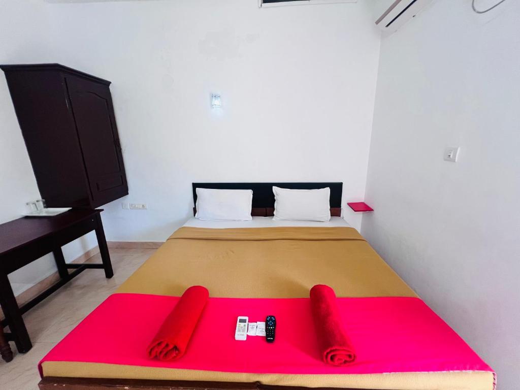 a bedroom with a large bed with a red blanket at Hotel Sunday - Townhouse Club Airport Trivandrum in Trivandrum