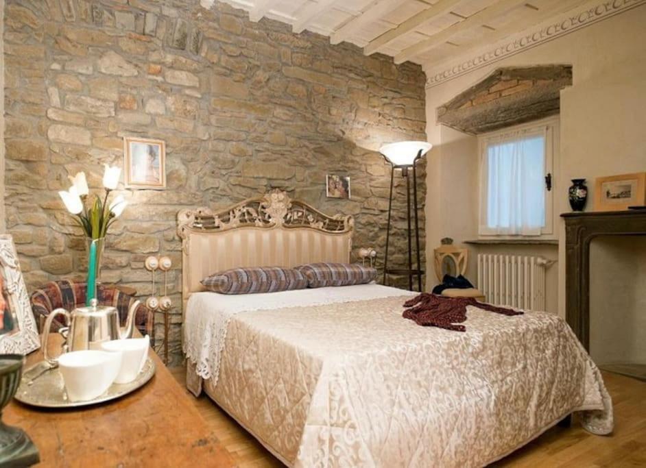 a bedroom with a bed and a stone wall at Casa Sofia in Fiesole