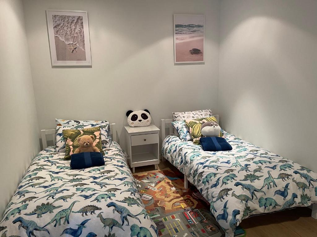 a bedroom with two beds and a stuffed animal on it at Glenelg resort style beachside apartment in Glenelg