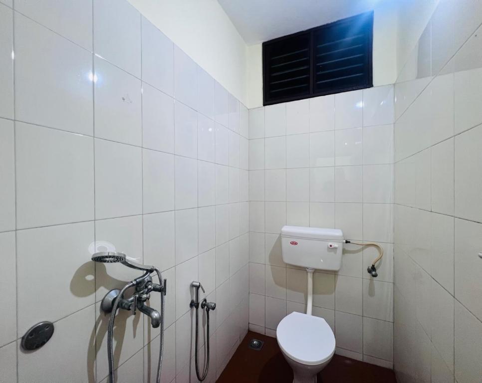 a bathroom with a toilet and a shower at Hotel Sunday - Townhouse Club Airport Trivandrum in Trivandrum