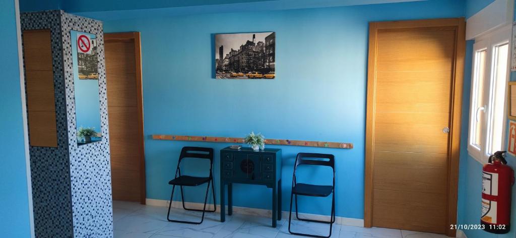 niebieski pokój ze stołem i dwoma stołkami w obiekcie Apartamento Zona Playa y centro Ciudad w mieście Santander