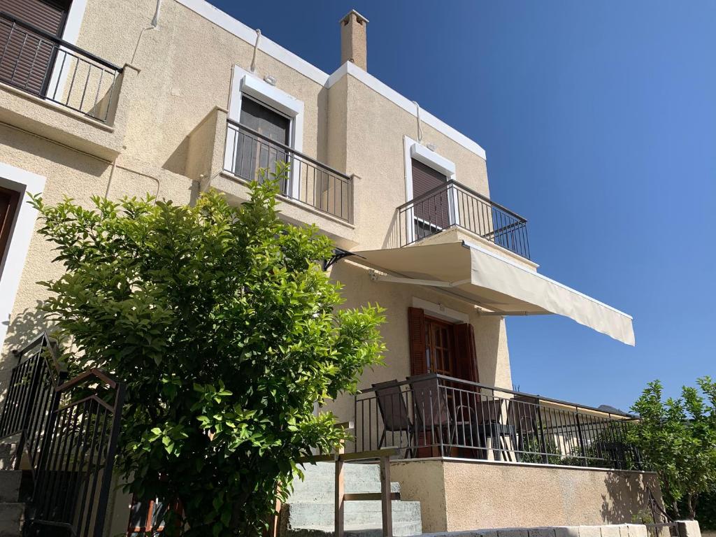 a building with balconies and a tree in front of it at La Bandolaise à Perdika in Perdhika