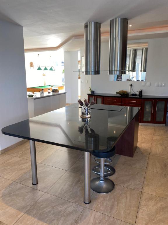 a kitchen with a glass table in a kitchen at Peach on Beach Boutique Guesthouse in Bloubergstrand