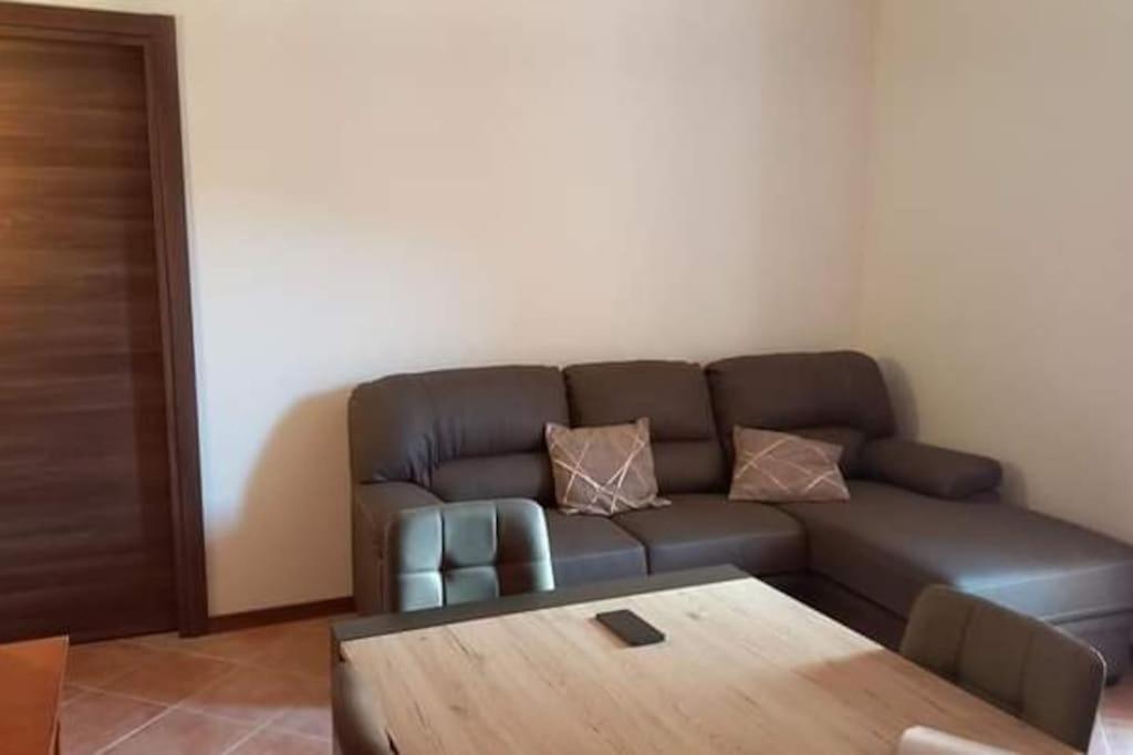 - un salon avec un canapé et une table en bois dans l'établissement Casa vacanza Petrari Residence Alt Air, à Ovindoli
