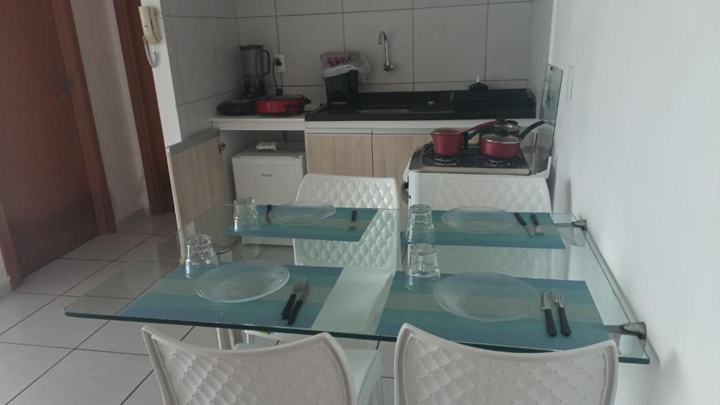 a glass table and chairs in a kitchen at Apartamento West Flat in Mossoró