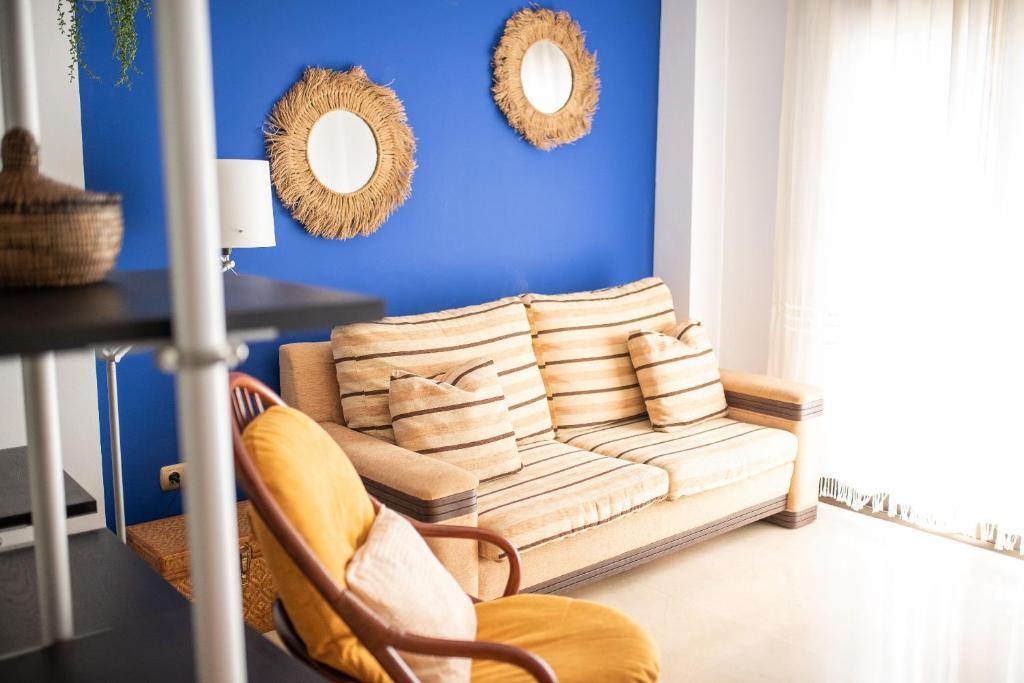 ein Wohnzimmer mit einem Sofa und 2 Spiegeln in der Unterkunft Acogedor apartamento en Vallada in Vallada