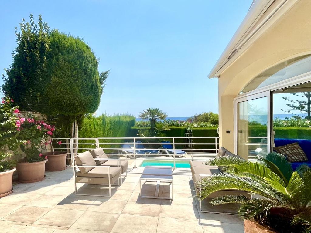 un patio con sillas y una piscina en Villa Catalina Stunning 4bedroom villa with air conditioning sea views & private swimming pool ideal for families, en L'Ametlla de Mar