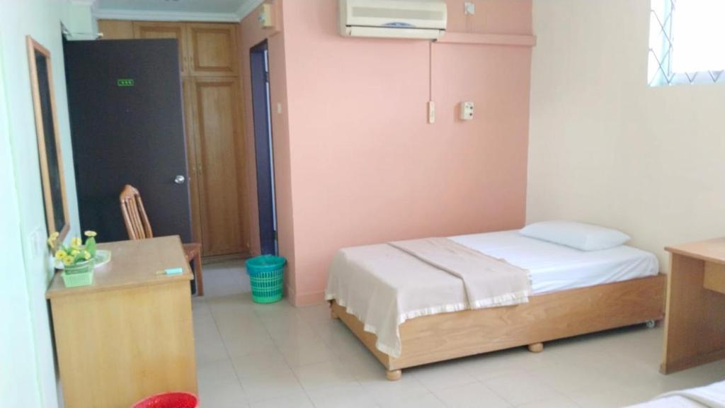 1 dormitorio con cama, mesa y escritorio en SUSAN HOTEL SEAFRONT, en Sandakan