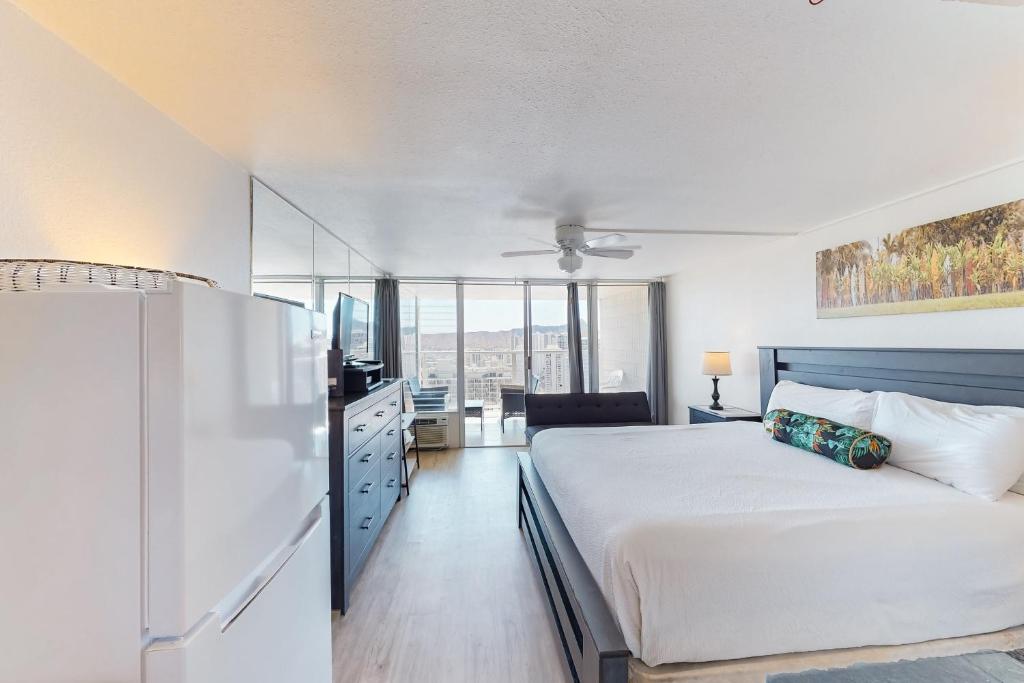 a bedroom with a white bed and a refrigerator at Island Colony 3715 in Honolulu