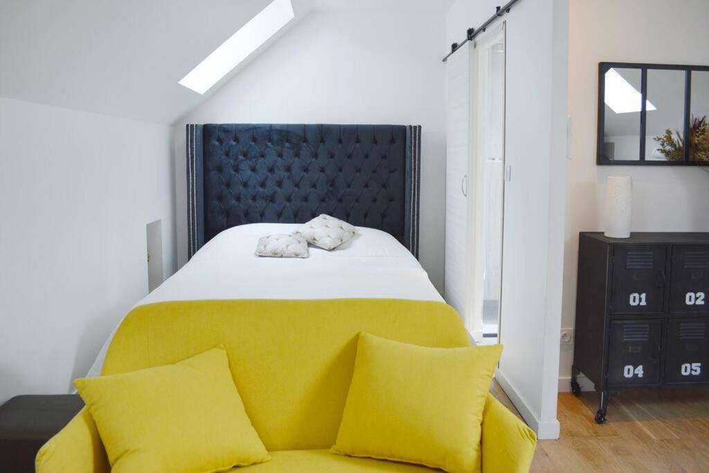 ein Schlafzimmer mit einem großen Bett mit gelben Kissen in der Unterkunft Gîte le Saint-Honoré in Saint-Avertin