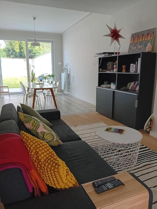 uma sala de estar com um sofá preto e uma mesa em Spacieux Appartement 1 chambre double & jardin em Bruxelas
