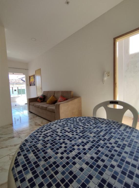uma sala de estar com uma mesa de azulejos azuis e um sofá em Apto 2/4 completo em Serrinha