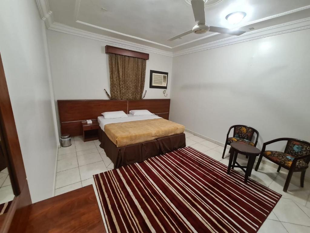 Un dormitorio con una cama y una alfombra roja. en شقق درة الصالحين, en La Meca
