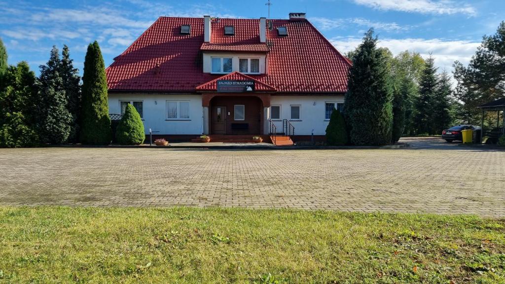 uma casa com um telhado vermelho e um quintal em Zajazd Stradomia em Stradomia Wierzchnia