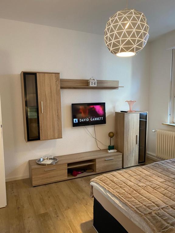 a living room with a tv and a bed at Schöne 2,5 Zimmer Wohnung in Dortmund-Hörde Phönix! in Dortmund
