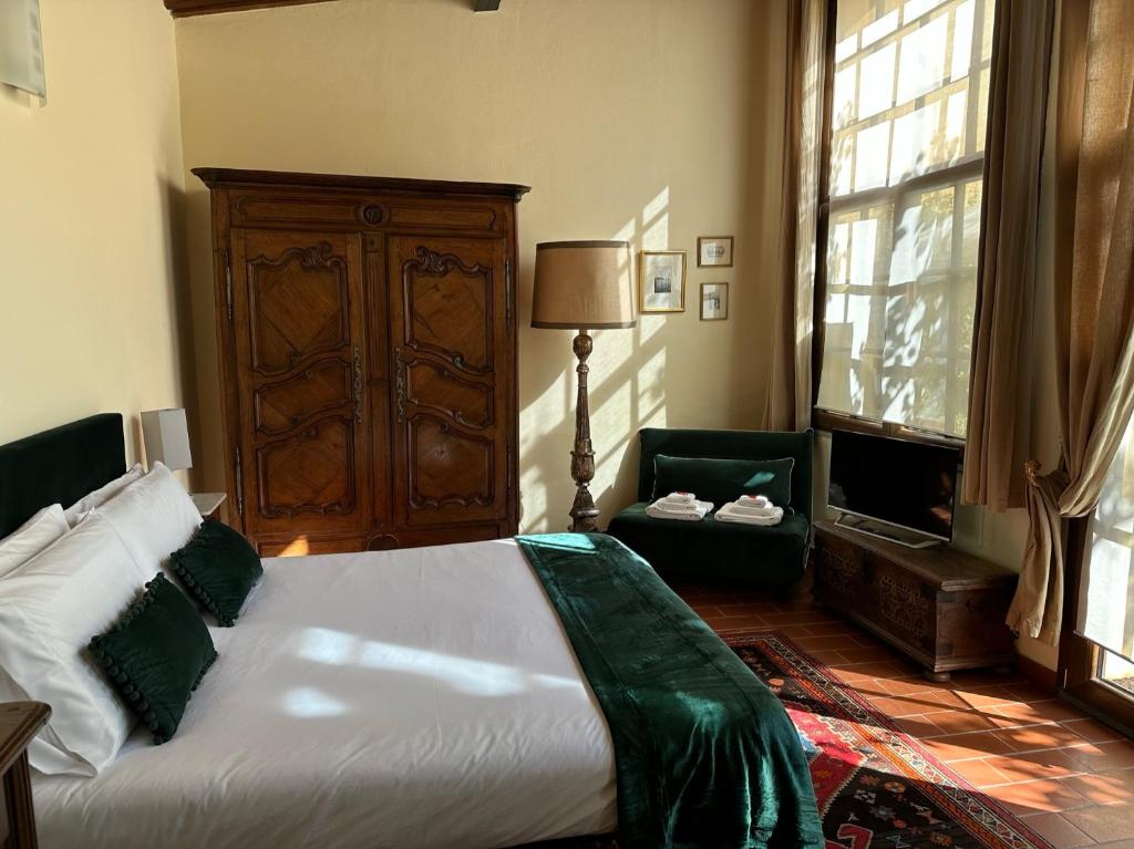 ein Schlafzimmer mit einem Bett, einem Stuhl und einem Fenster in der Unterkunft La Limonaia Firenze in Florenz