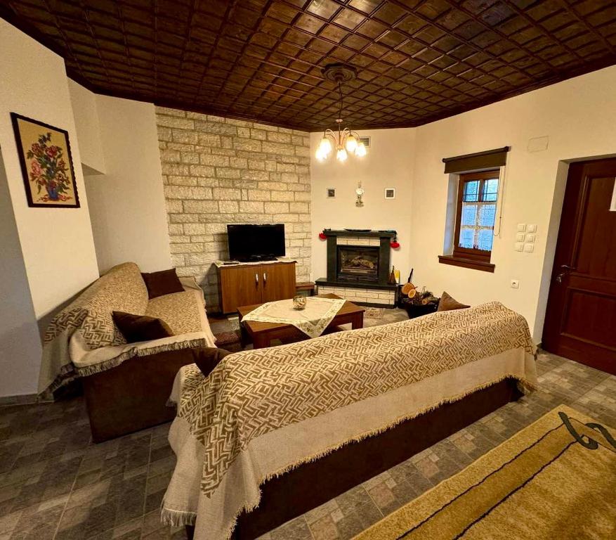 a bedroom with a bed and a couch and a fireplace at Vradeto Guesthouse in Vradéton