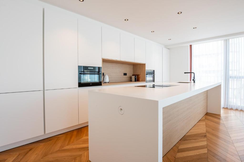 a kitchen with white cabinets and a large island at Dunvegan in Ostend