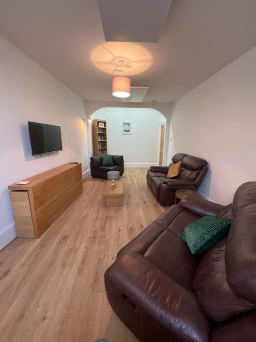 a living room with a couch and a television at Substantial 5 Bed Townhouse in Peterhead