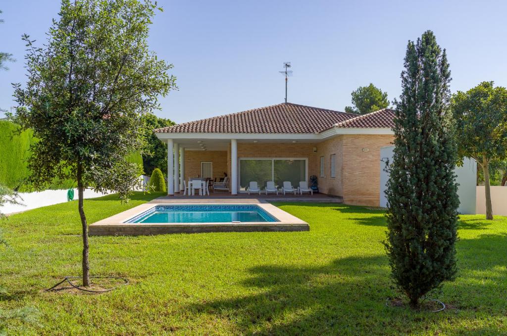 a house with a swimming pool in a yard at Villa con piscina, jardín y aire acondicionado en La Eliana-L'Eliana in Valencia