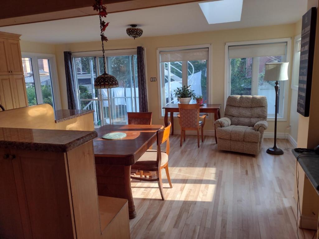 a kitchen and living room with a table and chairs at Montréal, Ahuntsic, 2 chambres, accueillant et charmant in Montréal