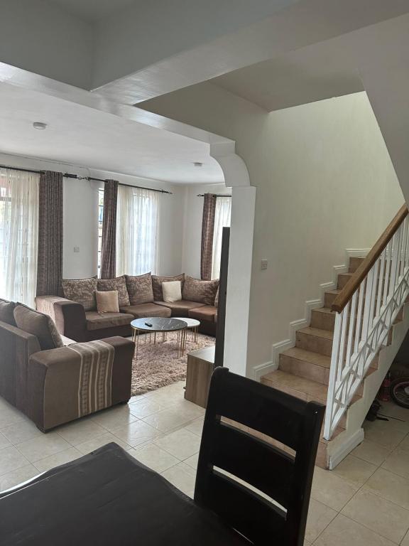 een woonkamer met een bank en een trap bij Arlshy furnished apartments in Kisumu