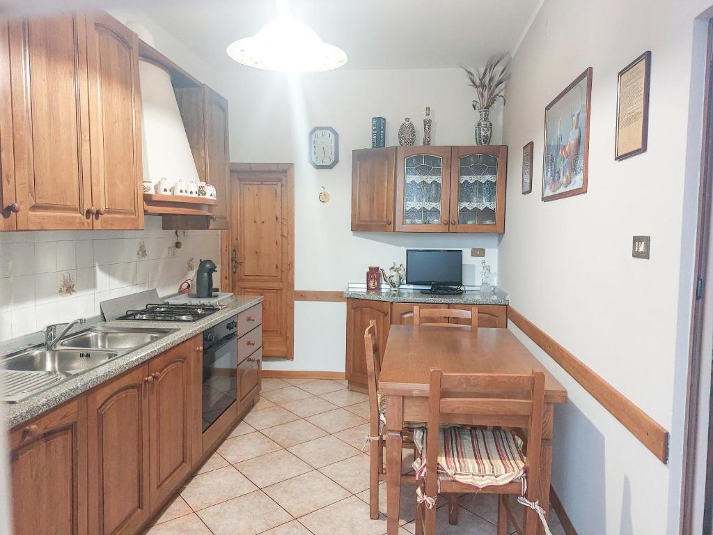 a kitchen with wooden cabinets and a wooden table at Pistoia ROSE Appartamento in Pistoia