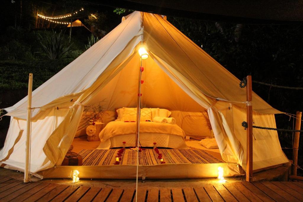 a white tent with a bed in it with lights at Milagros Glamping in Agustín Codazzi