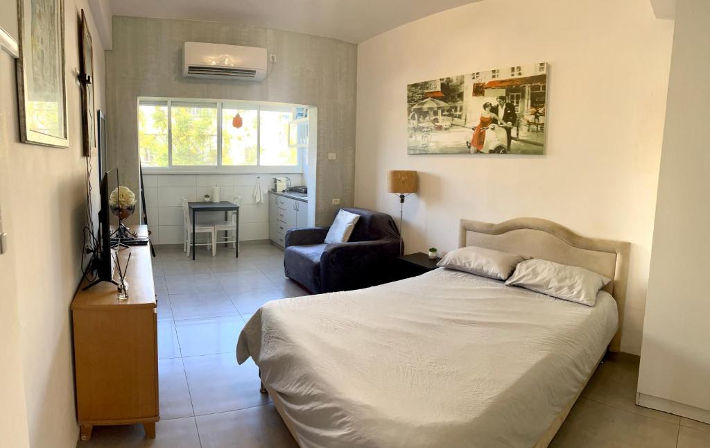 1 dormitorio con 1 cama y 1 silla en Cozy Studio Apartment in Haifa, en Haifa