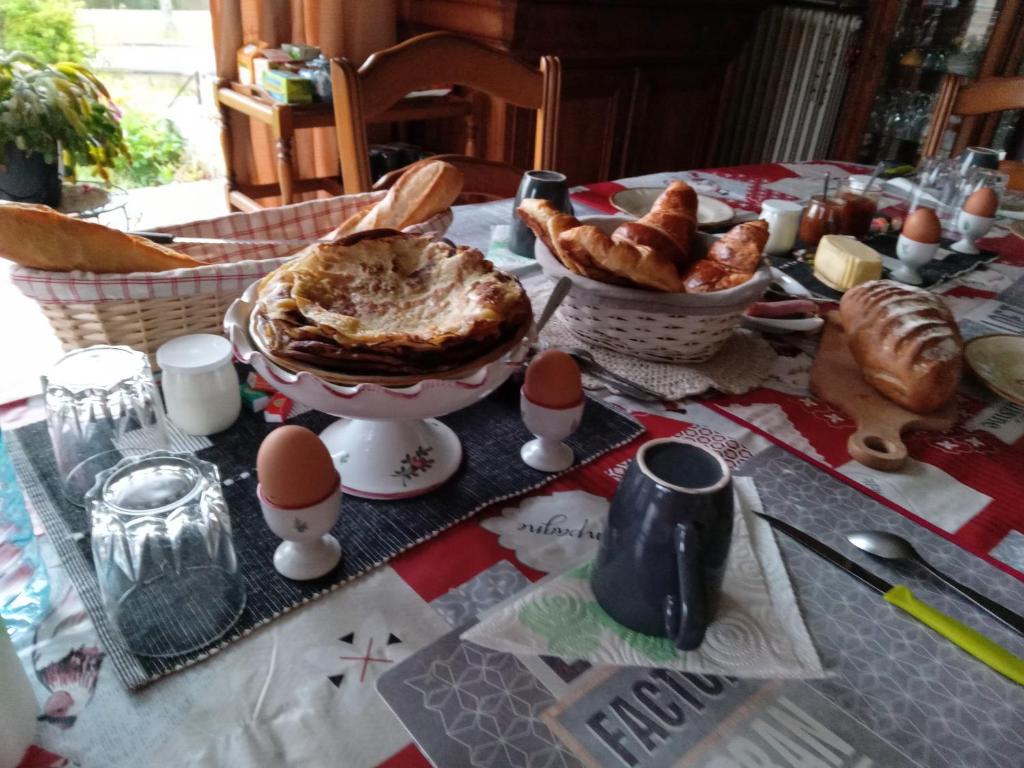 una mesa con huevos y cruasanes en Les Trois chambres de LYLY situées a Brou, en Brou