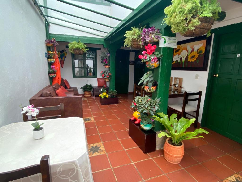 sala de estar con mesa y algunas plantas en Posada La Rioja, en Villa de Leyva